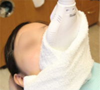 専用ライトを歯に当てられる女性